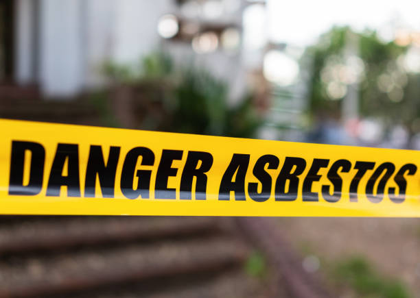 asbestos image Yellow cordon tape warning of asbestos danger at the entrance to a house being renovated.